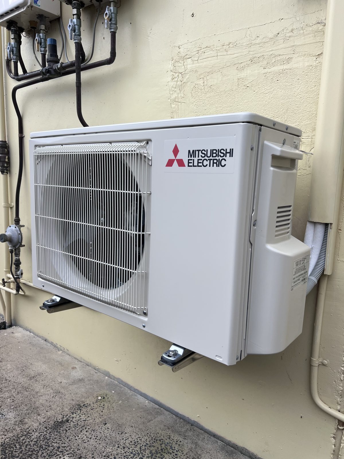 Neatly bracket-mounted Mitsubishi condenser with tidy pipework