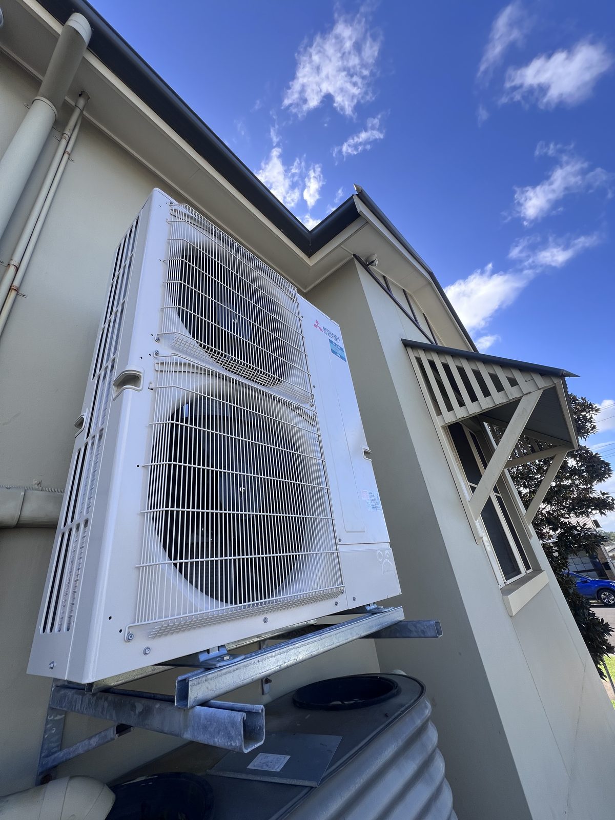 A Mitsubishi air conditioner installed against a clear blue sky by East Coast Air Conditioning